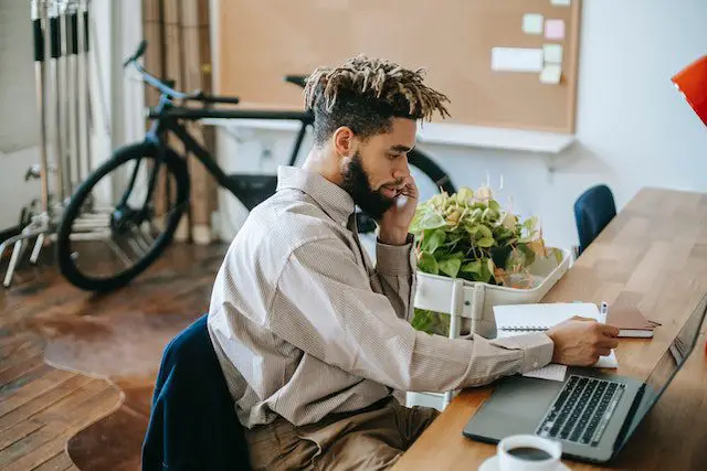 Black man working remotely on laptop in workspace