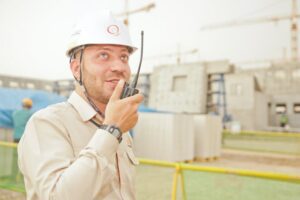 Man Wearing White Hard Hat Holding 2-way Radio