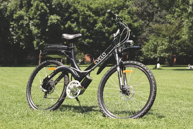 a black and white electric bike sitting in the grass