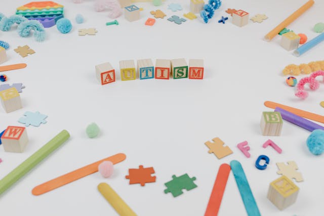 autism spelled using wooden blocks on a white surface