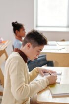 boy writing on his notebook