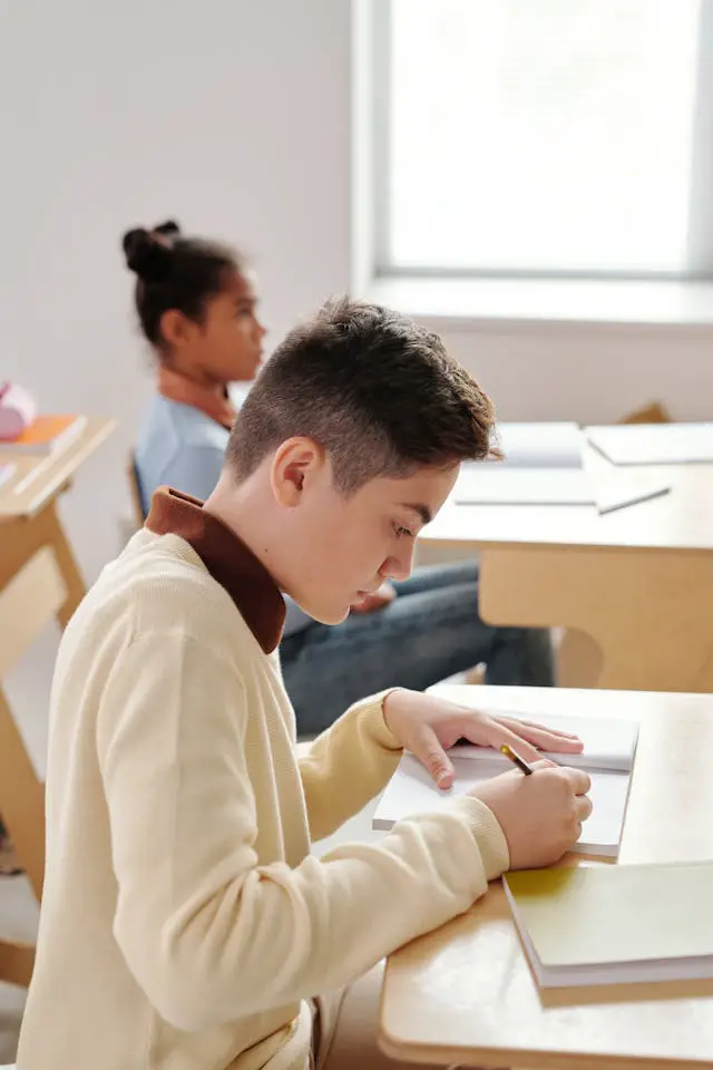 boy writing on his notebook