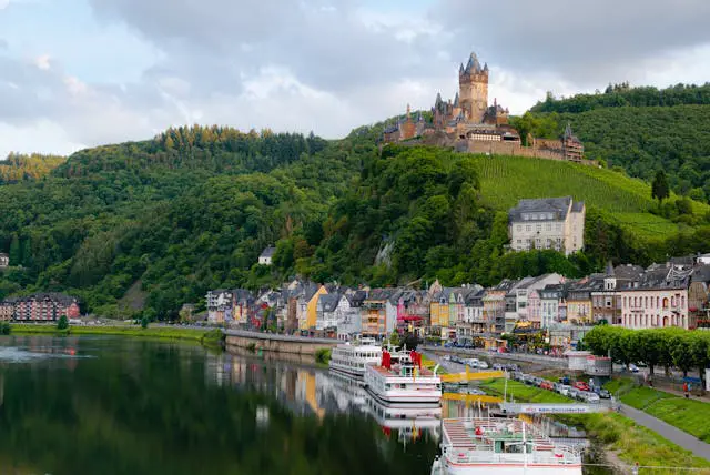 castle on hill over village near body of water