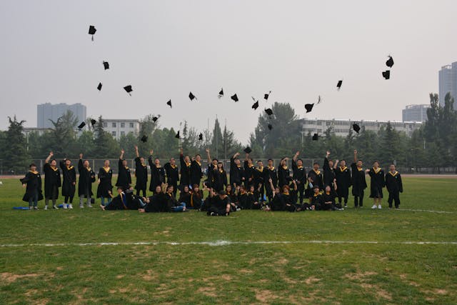 graduating class celebrates with cap toss outdoors