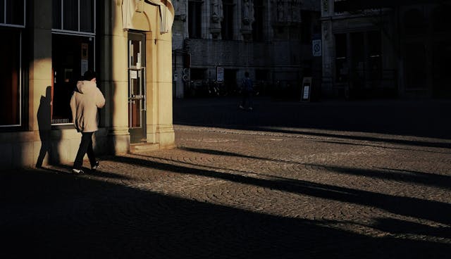 person walking near brown concrete building in the evening