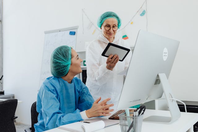 researchers wearing hair nets and coveralls in an office