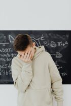 resigned young man in front of blackboard with trigonometry calculations