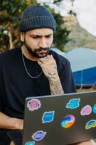 thinking man on warm cap sitting with laptop