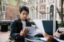 A Man in Plaid Long Sleeves Reading Papers