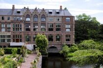 a large brick building with many windows next to a river