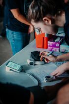 a young boy looking at a cell phone on a table