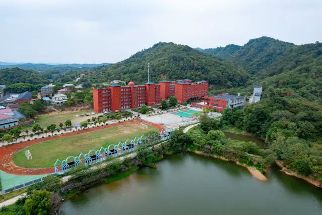 aerial view of red brick campus in lush valley