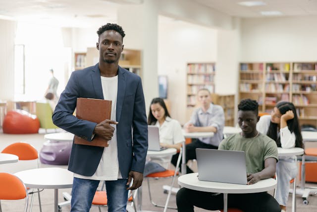 man wearing blazer standing in front of the class