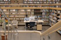 photo of man using computer in library