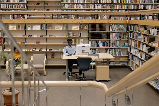 photo of man using computer in library