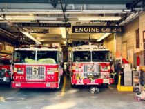 two fire trucks parked inside of a fire station