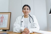 woman in white scrub suit wearing black stethoscope