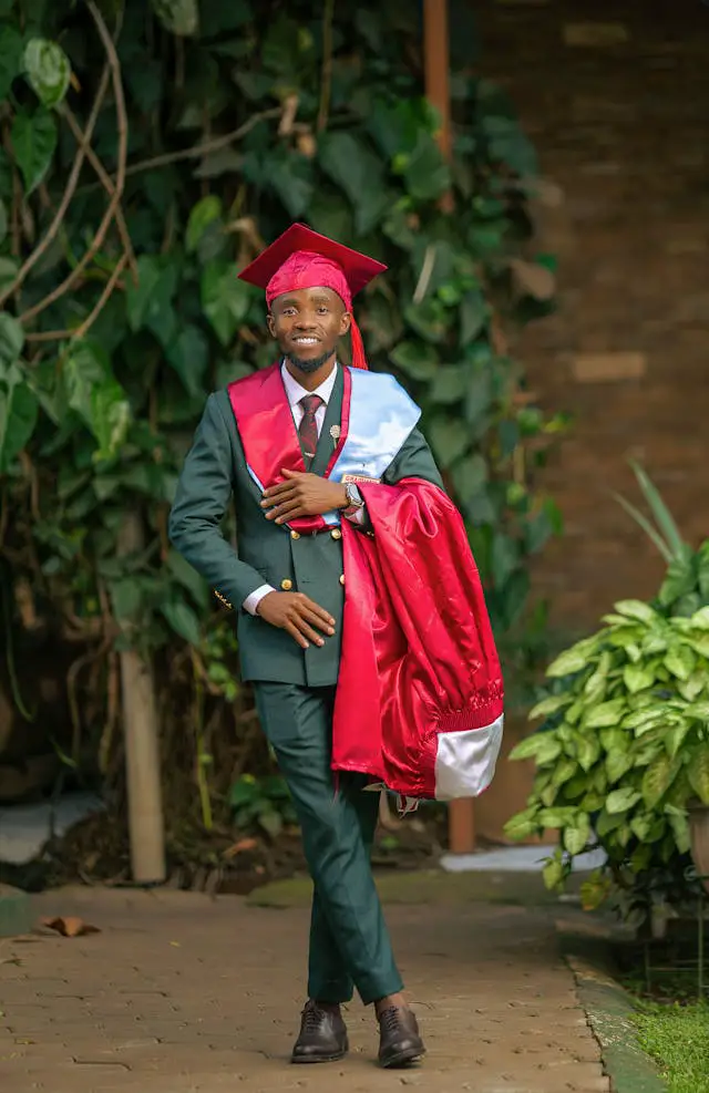 happy graduate in cap and gown outdoors