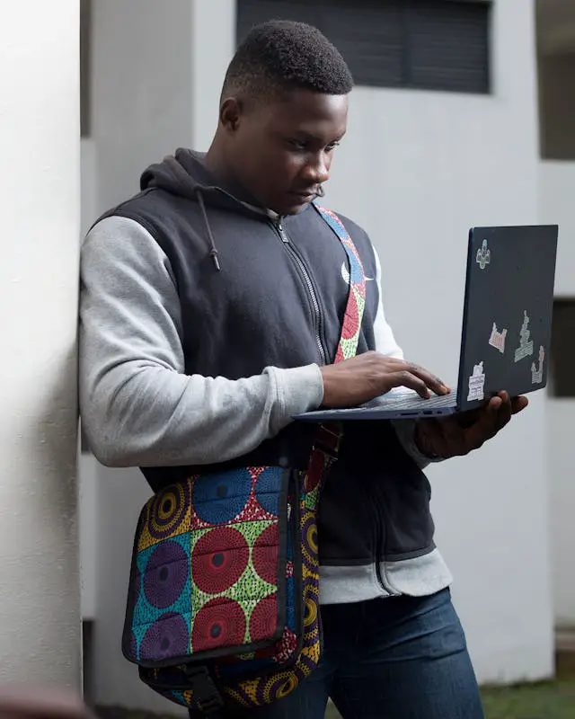 man standing and using a laptop