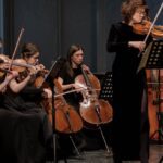 women playing violin near window