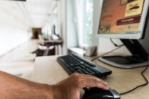 A person using a computer mouse on a desk