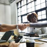 Free Stock Photo of Two business people shake across a table