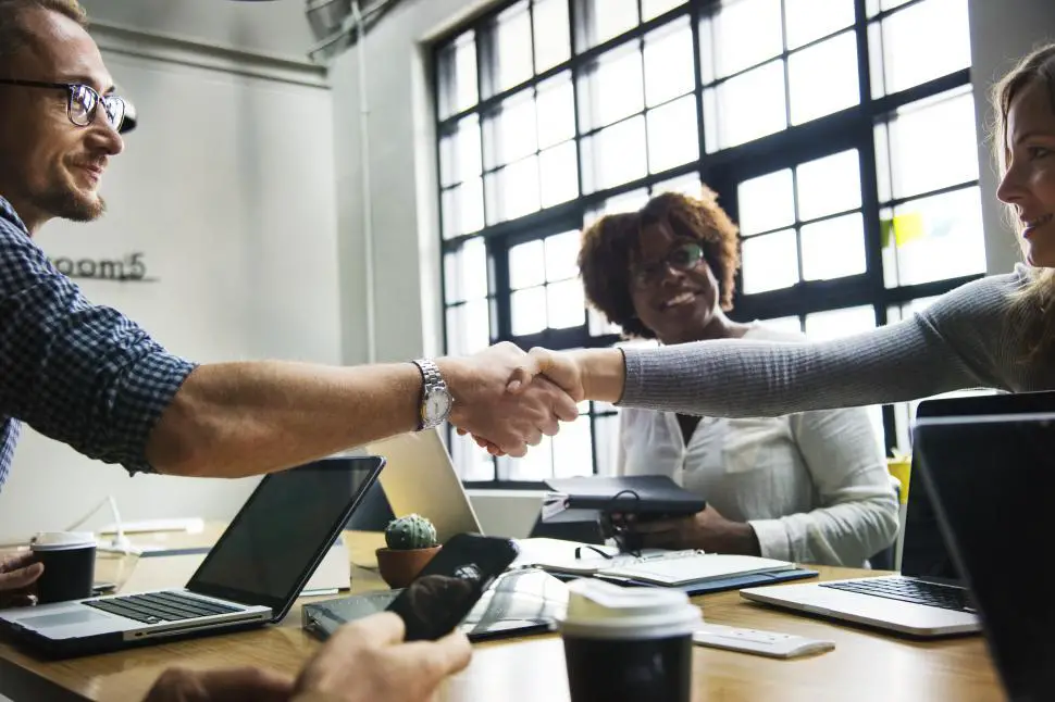 Free Stock Photo of Two business people shake across a table