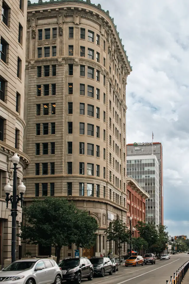 a city street lined with tall buildings and parked cars