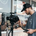 a man holding a camera and a tripod