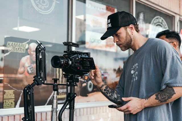 a man holding a camera and a tripod