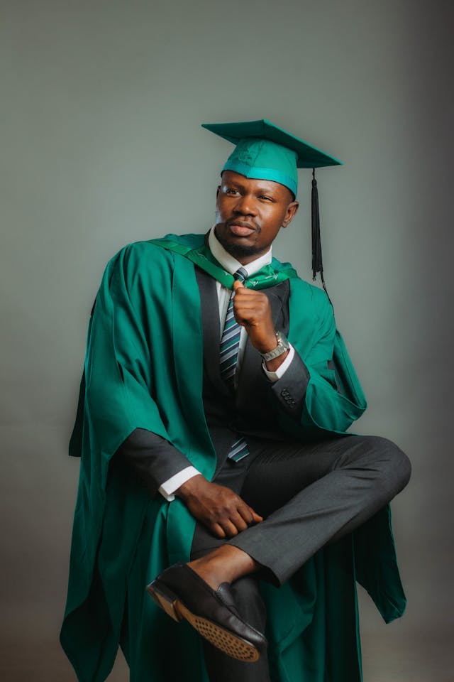 confident graduate in green gown and cap