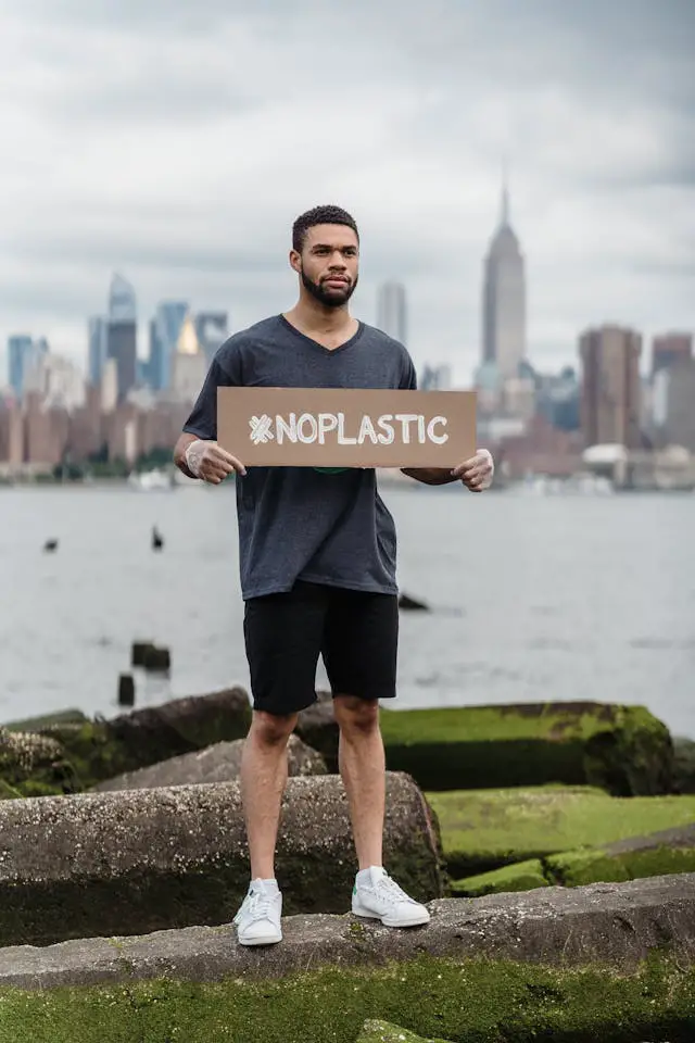 man in black crew neck t-shirt holding the beach signage