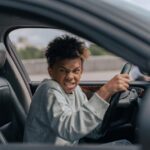 man in gray hoodie driving car