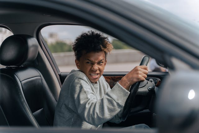 man in gray hoodie driving car