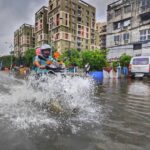 motorbike rides through flooded kolkata street