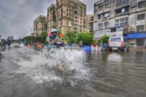 motorbike rides through flooded kolkata street