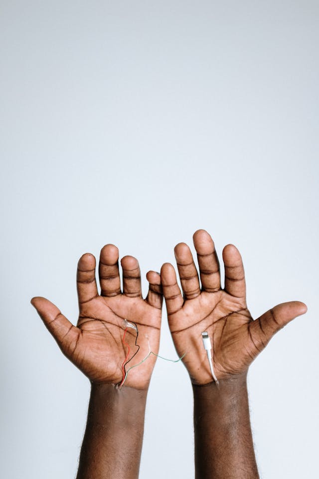 photo of hands with electric wires-and cable