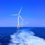 three white wind turbine on sea