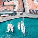 white and blue boat on water near brown concrete building during daytime