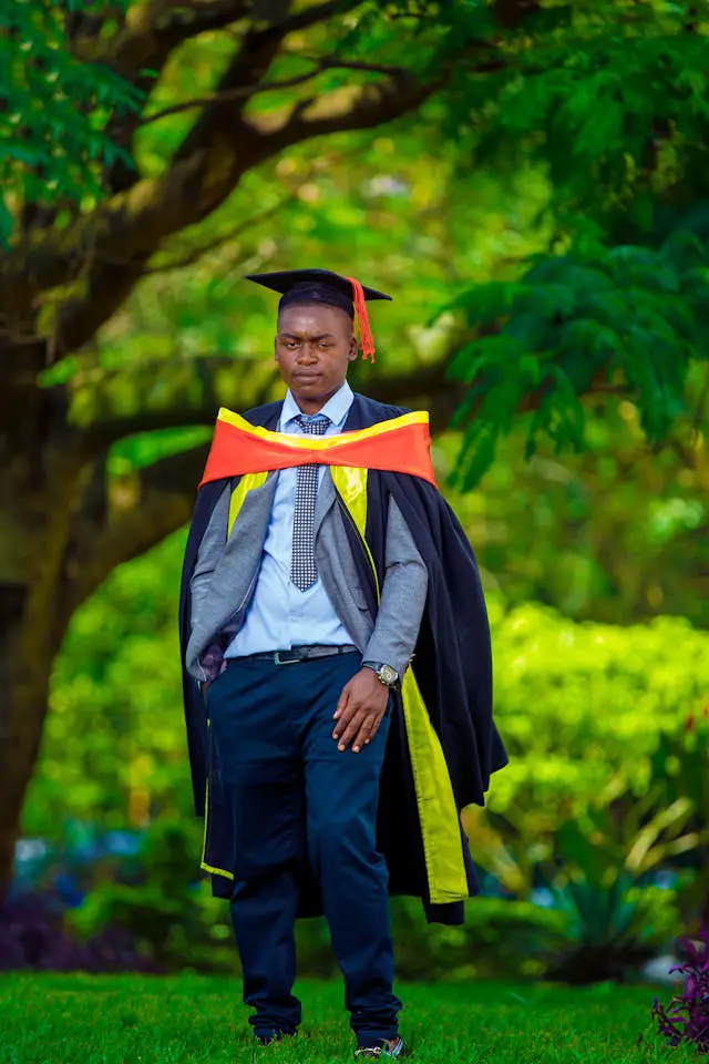 young graduate celebrating outdoors in cap and gown