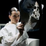 woman in white long sleeve top examining an x-ray