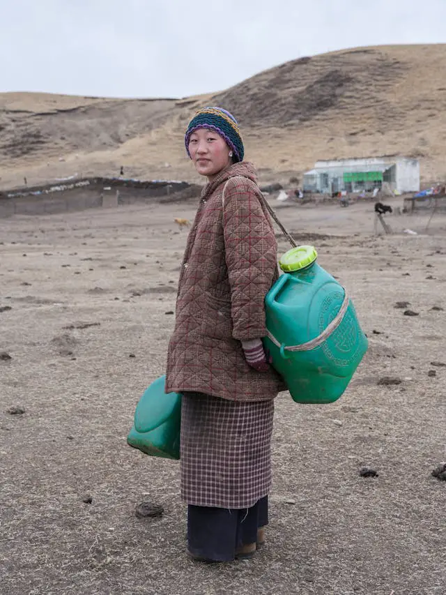 woman with bottles in village