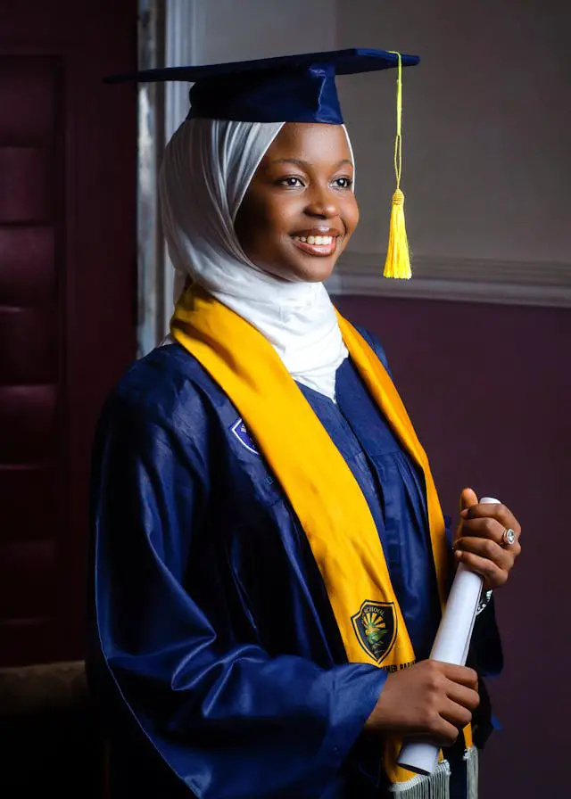 young muslim woman in graduation gown smiling