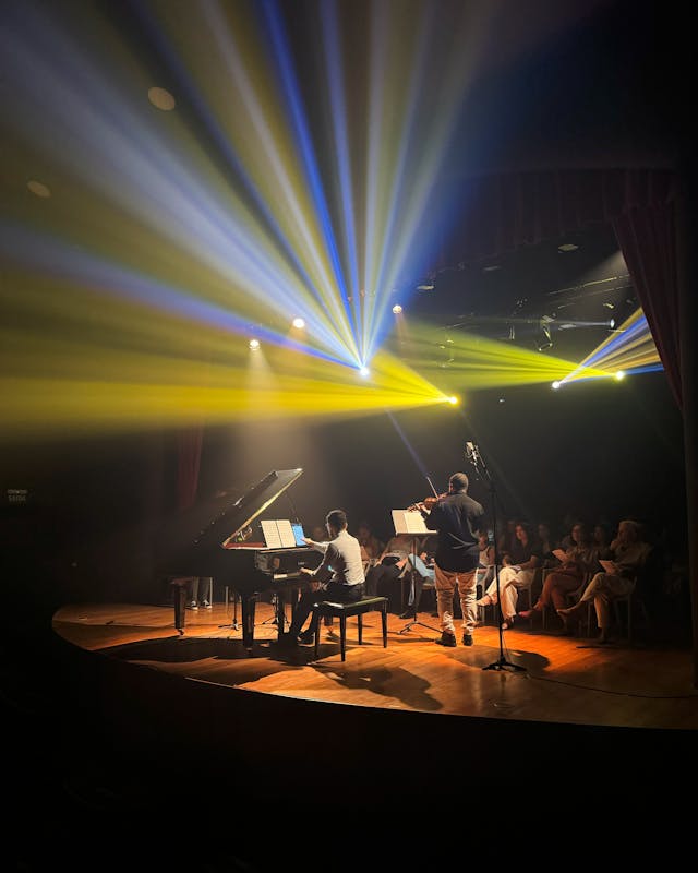 piano and violin duet performance with dramatic lighting